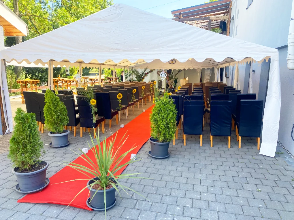 Hochzeitsfeier beim Restaurant Schlosscafe Beuren mit Zelt, schwarzen Stühlen und rotem Teppich