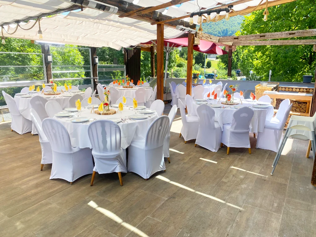 Runte Tische mit Gedeck und Stühle mit Hussen beim Restaurant Schlosscafe