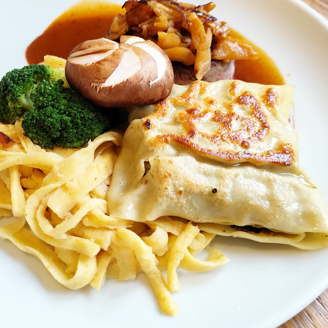 Spezialität des Hauses Maultaschen mit Spetzle auf einem Teller im Restaurant Schlosscafe in Beuren